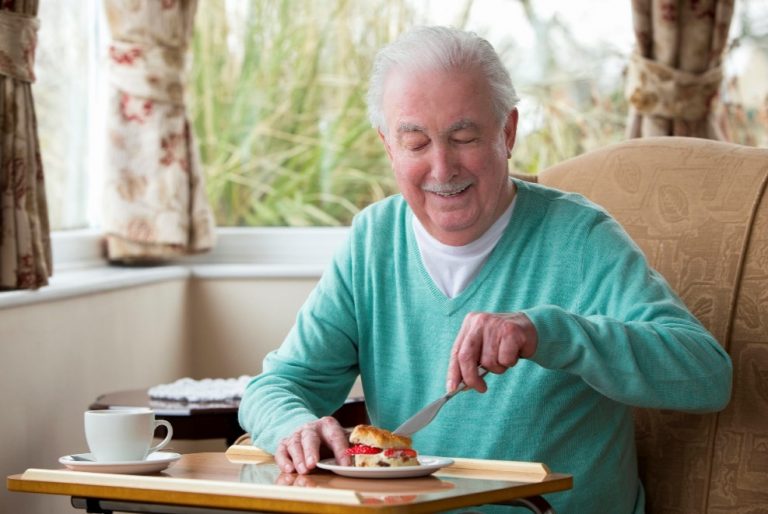 Happy senior man enjoying his breakfast