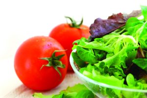 Tomatoes and lettuce being prepared for a salad