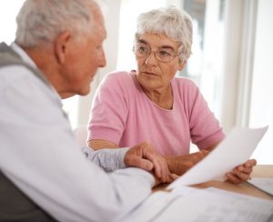 Cropped shot of two elderly people discussing a document